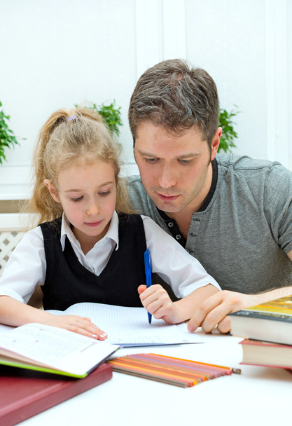 πατέρα, βοηθώντας την κόρη με τα μαθήματα στο σπίτι. - Φωτογραφία, εικόνα