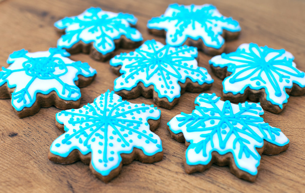 Schneeflockenförmige Kekse auf der hölzernen Tischplatte. - Foto, Bild