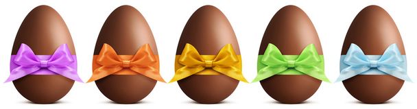 шоколадные пасхальные яйца с лентой Лук изолирован на белом фоне
 - Фото, изображение