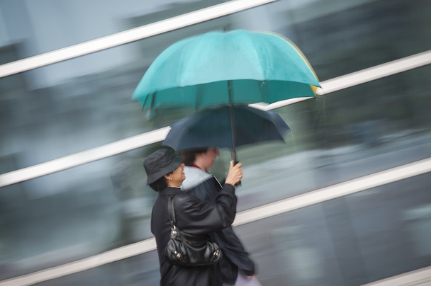 Deux femmes sous parapluie sous la pluie
 - Photo, image