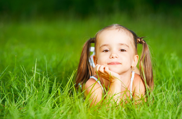 enfant heureux petite fille en robe blanche couché sur l'herbe été
 - Photo, image