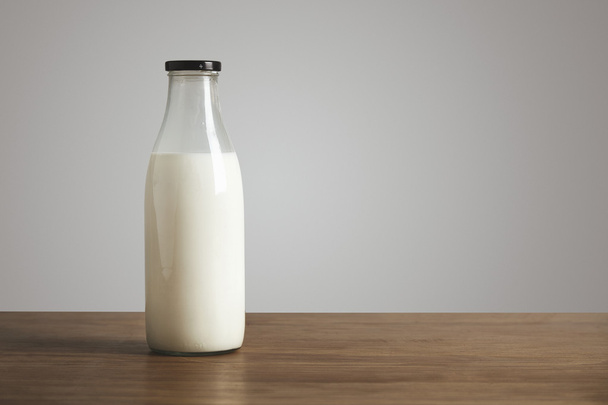 Antic blank bottle with milk on table - Foto, imagen