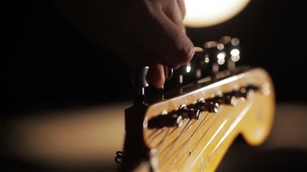 Macro close-up de dedos afinando estacas de guitarra
 - Filmagem, Vídeo