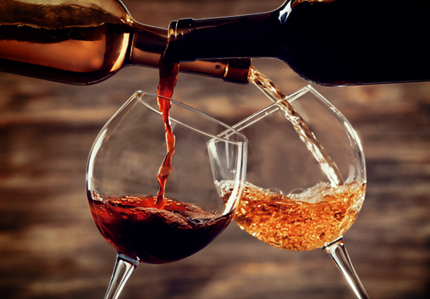 白ワインと赤ワインの木製の背景にグラスに注ぐ - 写真・画像