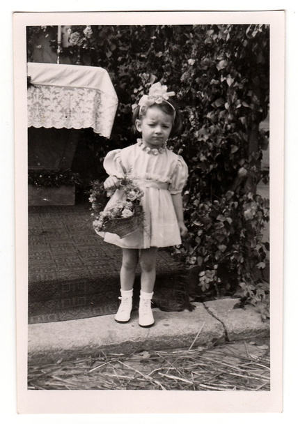 Vintage photo shows a small girl during religious (catholic) celebration, circa 1943. - 写真・画像