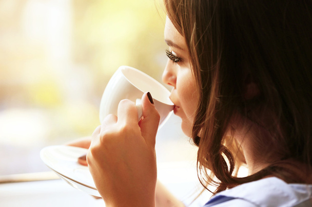 Young woman drinking coffee - Foto, immagini