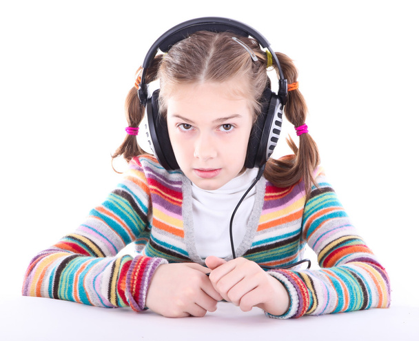 Happy little girl in headphones listens to music - Foto, imagen