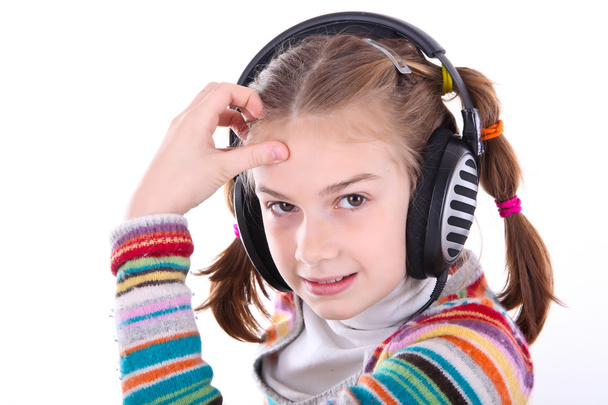 Happy little girl in headphones listens to music - Foto, imagen