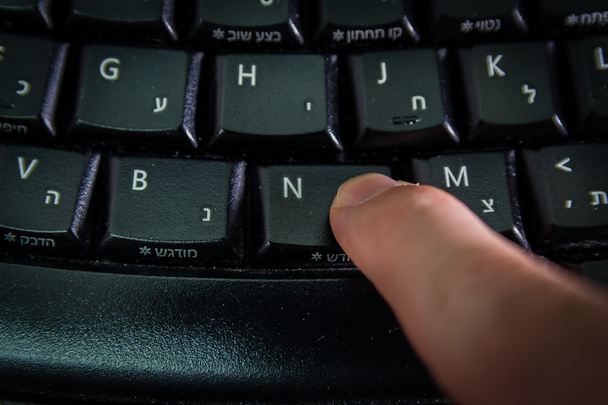 ヘブライ語と英語の文字をキーボードで入力する男 - 写真・画像