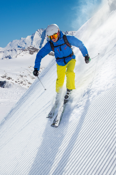 Esquiador esquiando cuesta abajo en las altas montañas - Foto, imagen