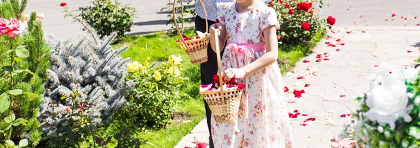 τα παιδιά κρατώντας ένα καλάθι με λουλούδια και ροδοπέταλα. - Φωτογραφία, εικόνα