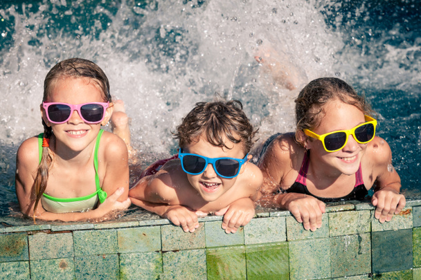 happy children  playing on the swimming pool at the day time - Φωτογραφία, εικόνα