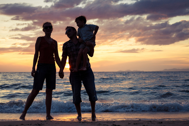 silhouet van gelukkige familie die spelen op het strand bij de sunse - Foto, afbeelding