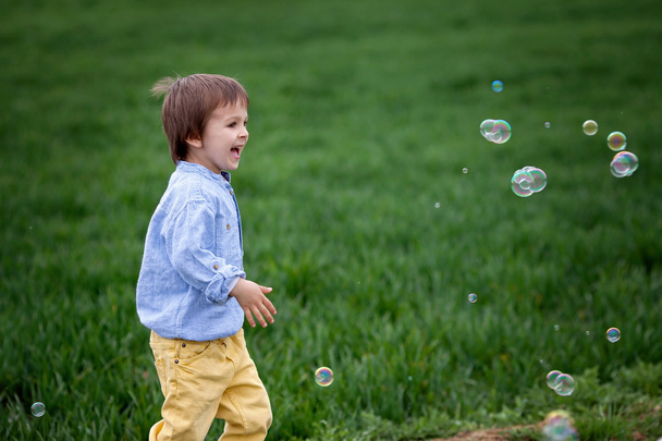 Little boy blowing soap bubbles, closeup portrait - Foto, Imagen