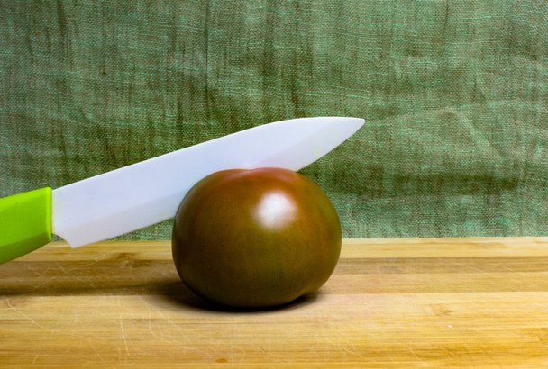 Cutting tomato with porcelain knife - Fotografie, Obrázek