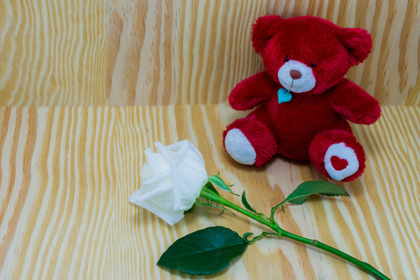 Red bear with white roses flower of love on Wood background - Fotografie, Obrázek