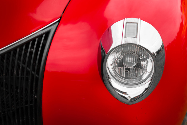 Right headlight of a red vintage car - Photo, Image
