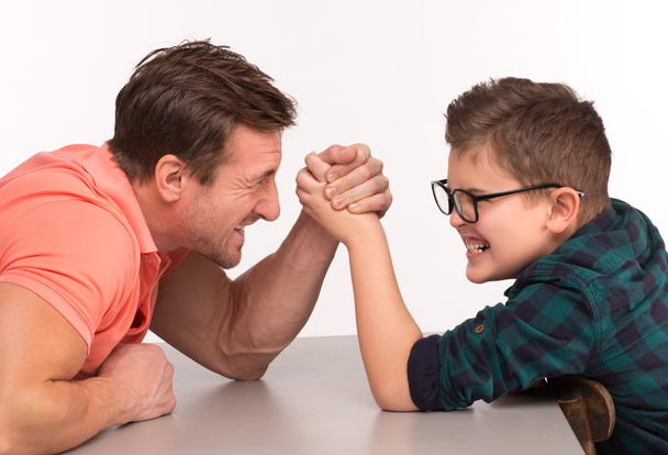 Young man and his son arm wrestling - Foto, Imagem