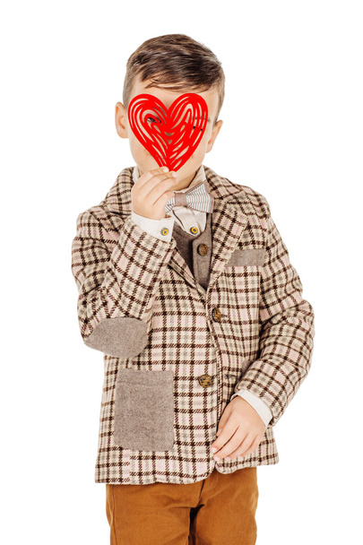 Smiling boy holding a red heart on his hand isolated on a white - Foto, afbeelding