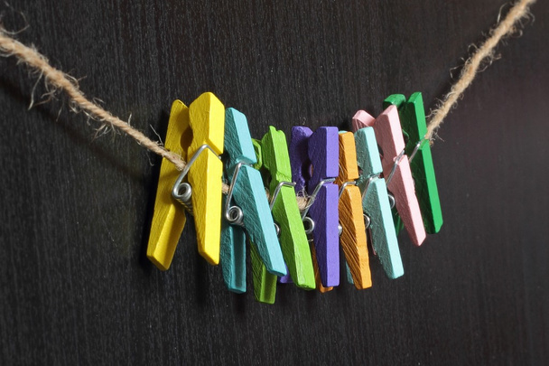 bir ip üzerinde küçük renkli clothespins dönüştürün - Fotoğraf, Görsel