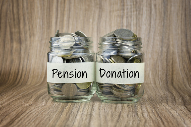 Due barattoli di vetro con monete etichettate Pension and Donation. Concetto finanziario
 - Foto, immagini