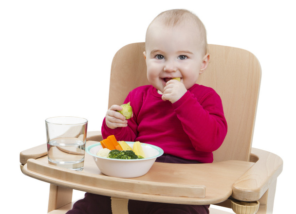 Niño pequeño comiendo en silla alta
 - Foto, imagen