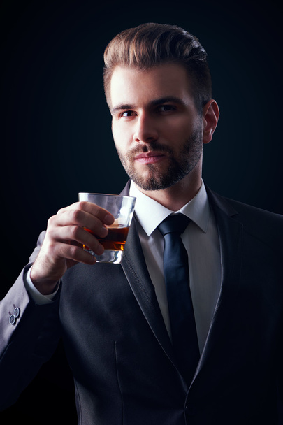 Businessman holding a glass - Foto, afbeelding
