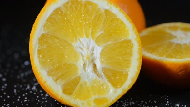 mandarine coupée en deux tourne sur un fond noir en point blanc
 - Séquence, vidéo