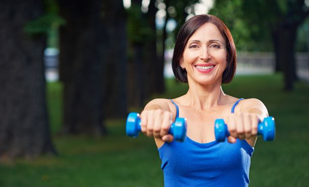 Woman exercising with dumbbells - Фото, зображення