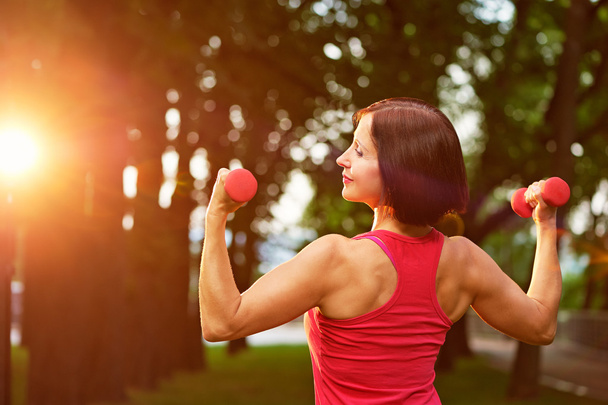 Woman exercising with dumbbells - Foto, Bild