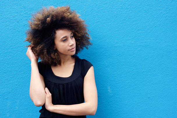 Jeune femme avec la main dans les cheveux afro
 - Photo, image