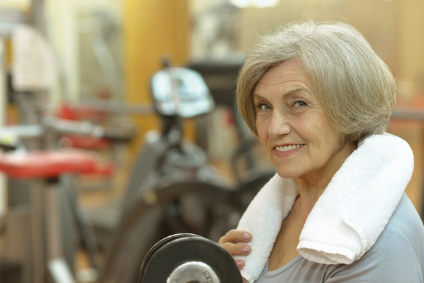 Elderly woman exercising in gym - Fotó, kép