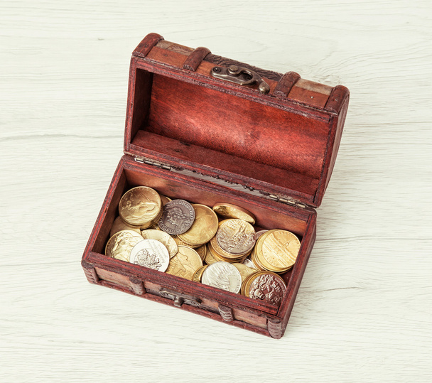 Дерев'яна грошова скриня, наповнена монетами
 - Фото, зображення