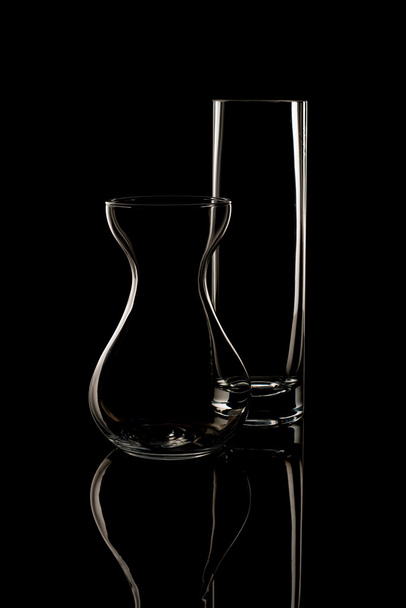 Vase und Trinkglas auf schwarzem Hintergrund - Foto, Bild