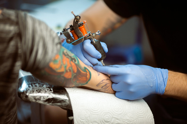 Tattooist makes a tattoo. Closeup - Photo, image
