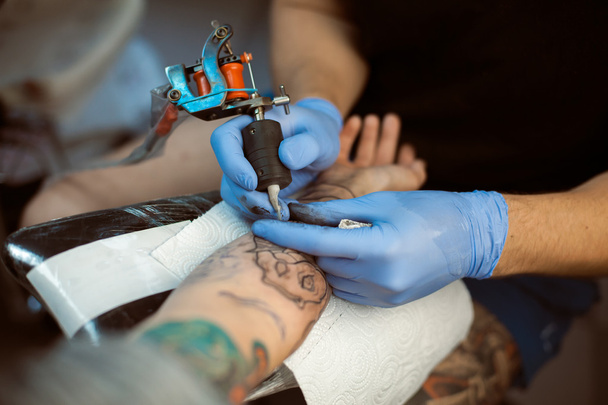 Tattooist makes a tattoo. Closeup - Photo, image