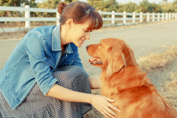 Beautiful woman with a cute golden retriever dog - Фото, зображення