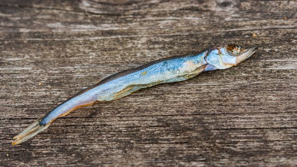 Сухая рыба с солью на деревянной поверхности
 - Фото, изображение