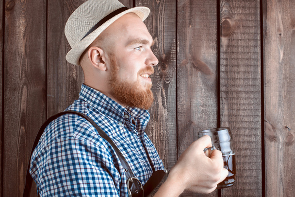 Happy smiling man with leather trousers (lederhose) holds oktoberfest beer glass - Zdjęcie, obraz