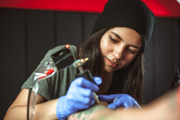 Beautiful brunette girl makes tattoo - Photo, Image