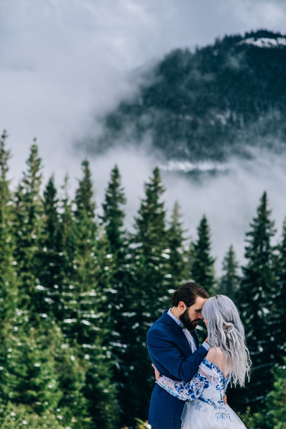 Bräutigam im blauen Anzug und Braut in Weiß auf der Bergautobahn - Foto, Bild