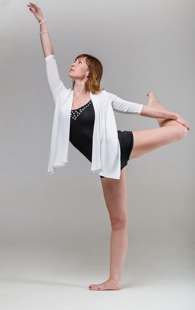 young woman ballerina ballet dancer dancing on gray background - Zdjęcie, obraz