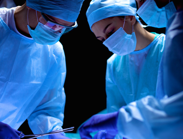 Team surgeon at work in operating room. - 写真・画像