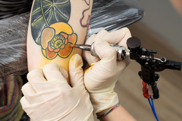  руки майстра малюють татуювання на машині
  - Фото, зображення