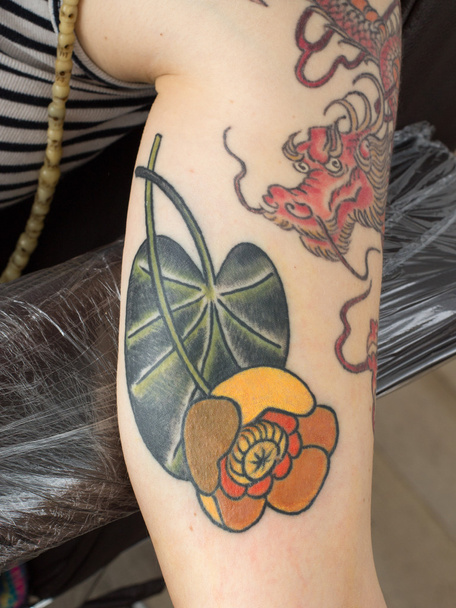 Farbige Spardose Blumen-Tätowierung auf dem Arm - Foto, Bild