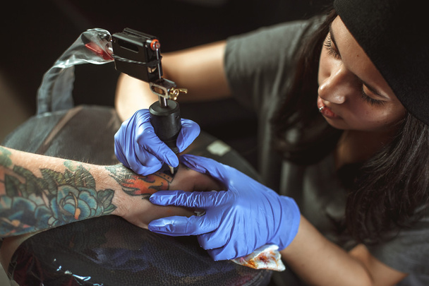 Beautiful brunette girl makes tattoo - Фото, изображение