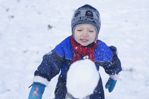 Garçon jouer avec une boule de neige
 - Photo, image