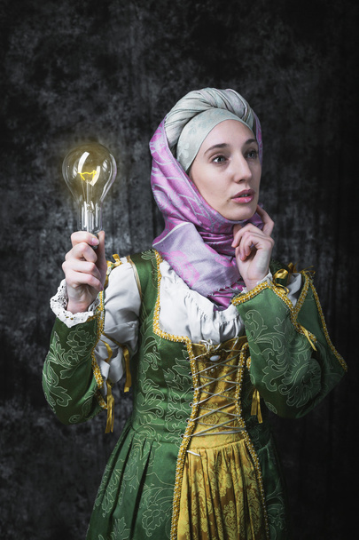 Keskiaikainen nainen, jolla on sähkölamppu
 - Valokuva, kuva