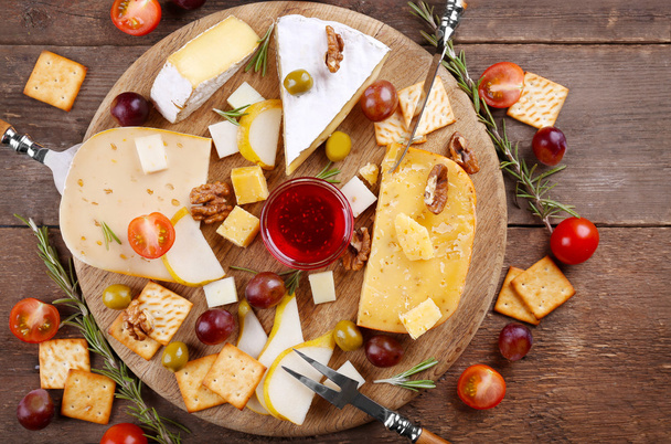Different kinds of cheese on wooden background - Fotó, kép