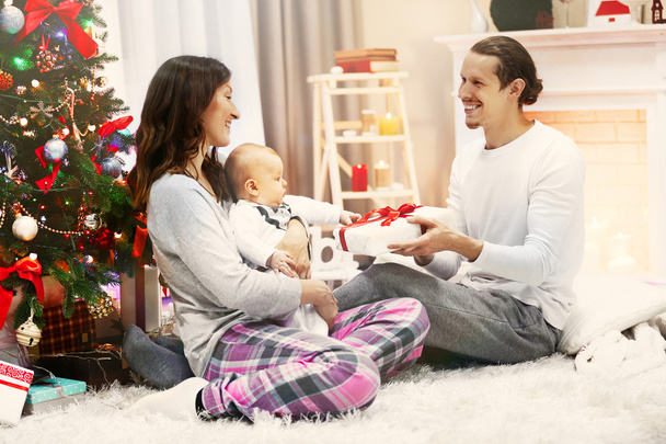 Parents with baby near Christmas tree  - Valokuva, kuva
